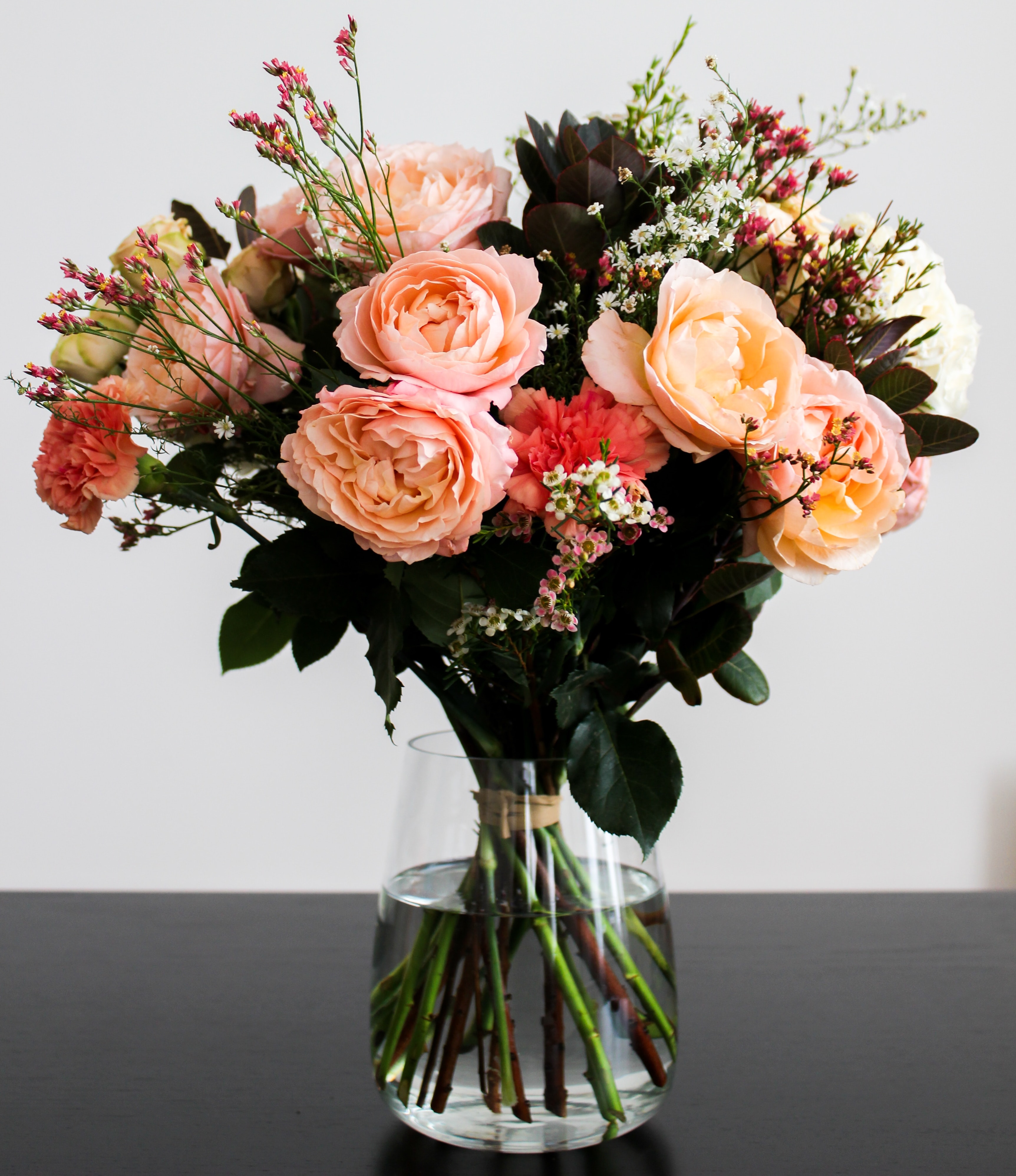 Picture of a bouquet of assorted orange flowers in a vase